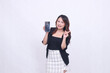 © Ajab - charm of beautiful Asian office girl 20s cheerful expression carrying cell phone gadget facing back while hand pointing left isolated white background