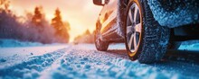 Closeup Side View Of Car With Winter Tires On A Road Covered With Snow, Blurry Snowy Background.