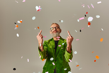 Wall Mural - good looking funky mature man in green blazer showing middle fingers at camera with closed eyes