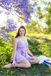 © Austockphoto - Summer scene of teen girl sitting on grassy slope relaxing outside