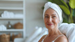 A mature happy woman in her 70s, a white caucasian at a day spa salon, wearing a headband, advert for skincare health products for mature menopause skin for anti ageing and relaxation wellness