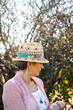 © Austockphoto - Senior woman wearing a hat in the garden looking to the side