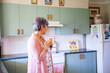 © Austockphoto - Middle aged woman drinking a cup of tea in her kitchen