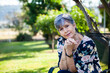 © Austockphoto - Mature aged woman relaxing in backyard under shady tree