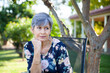© Austockphoto - Mature aged woman relaxing in backyard under shady tree