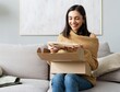 © opolja - delivery, mail and people concept - smiling woman opening cardboard box at home.