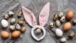 easter bunny ears from napkins and eggs quail and chicken eggs gray textile background happy easter top view flat lay