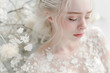 © Koriolis - Portrait of a fair woman with platinum blond hair in a  wedding dress among the delicate white flowers.