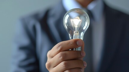 Close-up, Hand of businessman holding illuminated light bulb, idea, innovation and inspiration concept