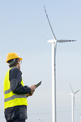 Canvas Print - Engineer with tablet computer on a background of wind turbines