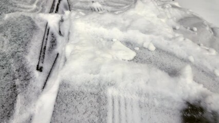 Wall Mural - Man with brown leather gloves uncovering the car front window from frozen snow in winter