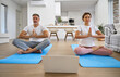 © insta_photos - Calm middle aged couple learning online yoga using laptop at home. Happy senior healthy mature man and woman doing yoga training exercises meditating with computer in modern house living room.