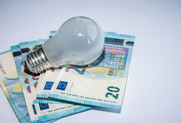 Light bulb on a euro money. Top view. Flat lay. White background.