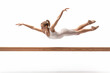 Portrait of teenage girl practicing rhythmic gymnastics in gym over white background