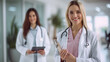© MP Studio - smiling female healthcare professional in the foreground holding a clipboard with a stethoscope around her neck