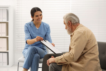 Sticker - Smiling nurse with clipboard and elderly patient in hospital