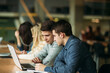 © Aleksandr - Group of college students studying in the school library, a girl and a boy are using a laptop and connecting to internet