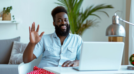 Canvas Print - man with a beard smiling and waving at the camera, possibly during a video call, in a bright indoor setting with modern decor.