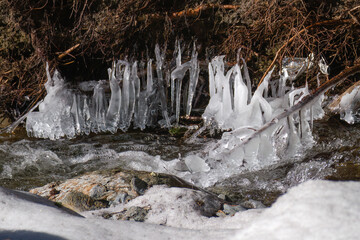 Wall Mural - beautiful icicles and light in mountain creek at a winter day 