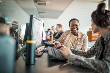 Diverse young students using computer in university lab