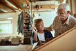 © Marko Geber - Grandfather and grandson building a wooden model in a workshop