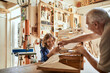© Marko Geber - Grandfather and grandson building a wooden model in a workshop