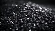 Abstract close-up of black plastic pellets with dramatic lighting