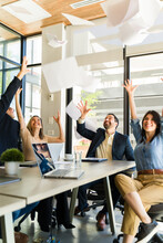 Group of businesspeople excited about the weekend throwing papers in the air