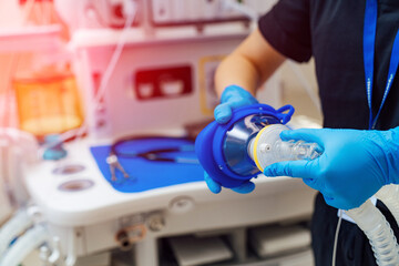 Doctor holds mask and ventilator in his hands