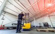 © Vadim - Warehouse worker loading pallet with forklift into truck