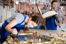 Young Female Furniture Workshop Worker Repairing Vintage Mirror