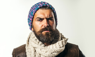 Sticker - Closeup portrait of handsome bearded man in leather jacket, woolen scarf and knitted hat. Serious stylish guy in autumn-winter clothing. Men seasonal fashion. Casual look. Warm wear for cold season.