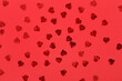 Leinwandbild Motiv Many small hearts with sequins on red background