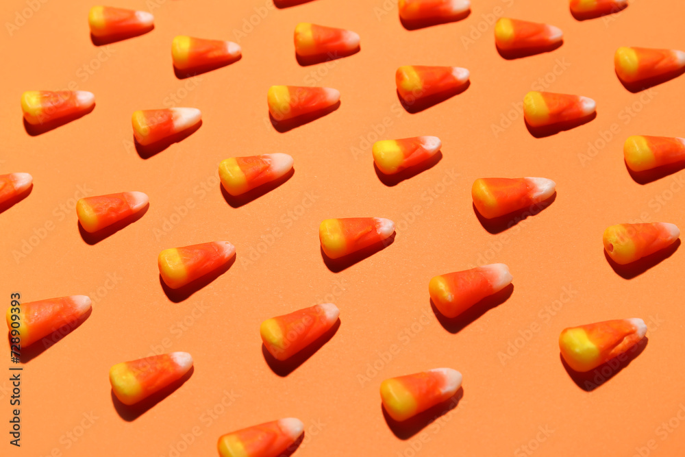 Many candy corns on orange background