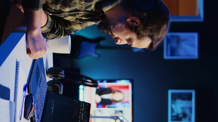 Poster - vertical video skilled computer scientist writes code on laptop screen while in living room office u