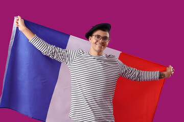 Wall Mural - Young man with flag of France on purple background