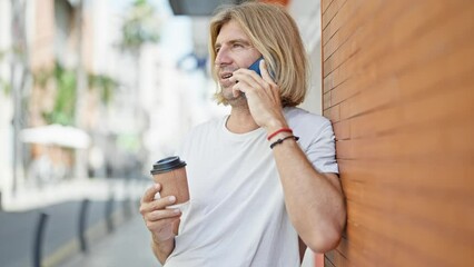 Sticker - A smiling blond man enjoying a phone call while holding a coffee cup against an urban backdrop.