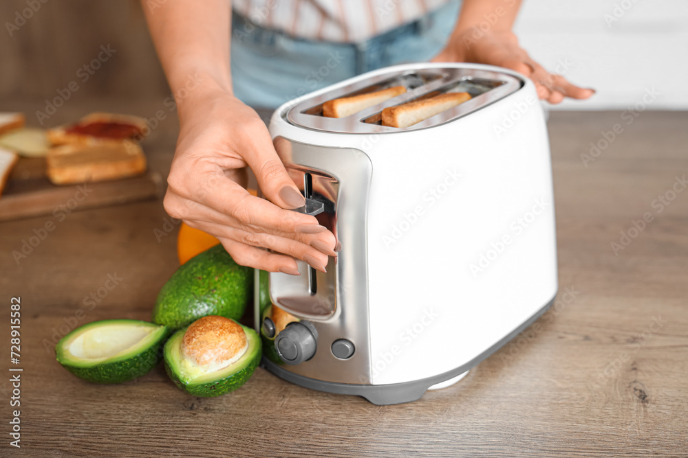Young beautiful woman making tasty toasts in kitchen, closeup