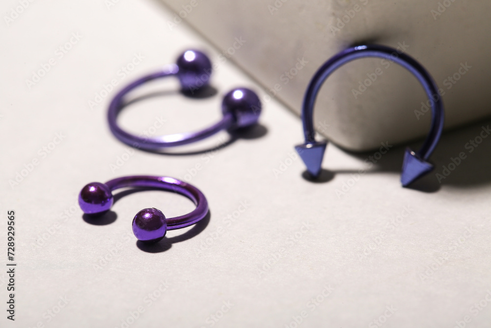 Set of circular barbells for piercing on light background