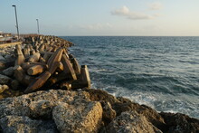 View On Concrete, Artificial, Processed Breakwater Stones Piled Up In Wave Breaker To Protect Port Of Bridgetown, Barbados From Waves Of Caribbean Sea. In Forward Is Stone Wall.