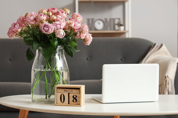 Wall Mural - Calendar with date of International Women's Day, roses and laptop on table in living room