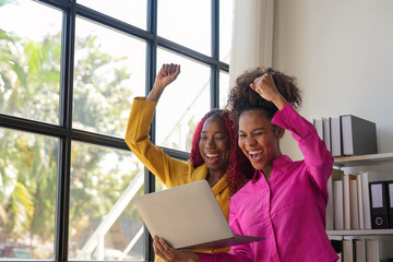 Two african woman celebrate when business goal success. achievement and business goal success concept