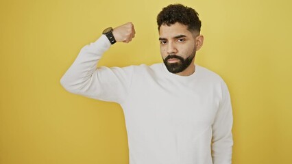 Poster - Young man standing strong person showing arm muscle, confident and proud of power over isolated yellow background