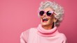 © liliyabatyrova - A close-up portrait of a happy smiling gray-haired fashionable senior woman with makeup and hairstyle on a pink background with a copy space. Retirement Life, Emotions Concepts.