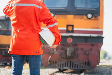 Wall Mural - Close-up at a worker is holding white safety helmet, posing on crude oil tanker freight train as blurred background. Safety working in the challenge industrial concept scene.
