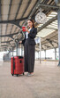 © asean studio - Young asian business woman holding phone and passport at a train station, waiting to departure to the city center
