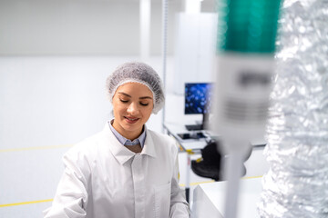 Wall Mural - Experienced female technologist controlling production process in factory.