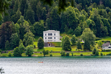 Wall Mural - Scenic view of lakeshore with promenade at Lake Bled on a cloudy summer day. Photo taken August 8th, 2023, Bled, Slovenia.