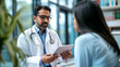 © Graphic Master - Confident indian doctor using a digital tablet to explain test results to a patient,
