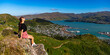 pretty hiker girl enjoying the panorama of lyttelton after finishing the hike on the bridle path from christchurch to lyttelton; beautiful view from gondola summit station, canterbury, new zealand 